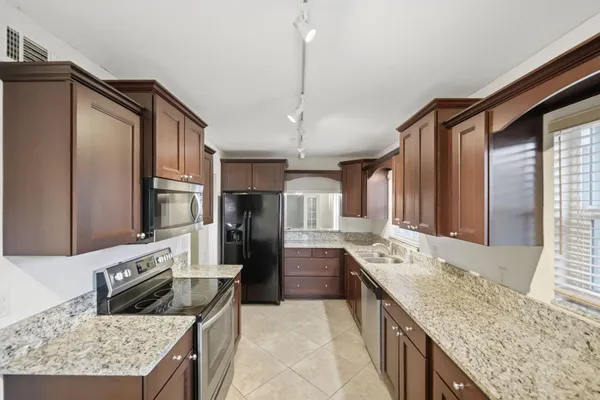 a kitchen with stainless steel appliances granite countertop a sink stove and refrigerator