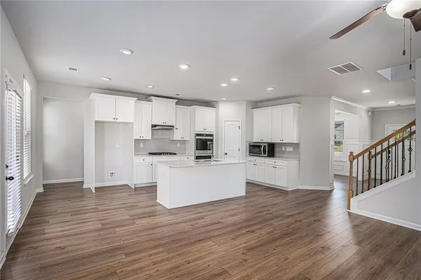 a view of kitchen with wooden floor and electronic appliances