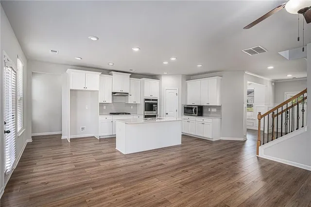 a view of kitchen with wooden floor and electronic appliances