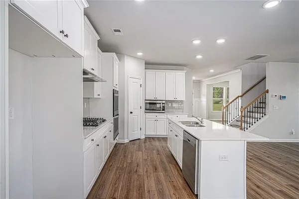 a kitchen with white cabinets sink and stainless steel appliances