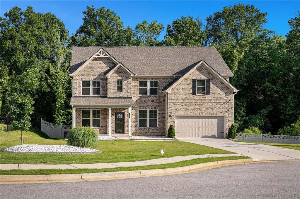 953 Mystic Way Hampton, GA 30228 - Photo 2 of 51 a view of a white house with a large windows and a yard with plants and large trees