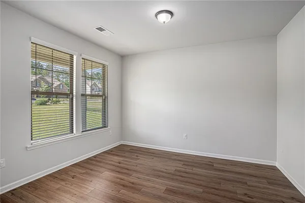 a view of an empty room and chandelier fan