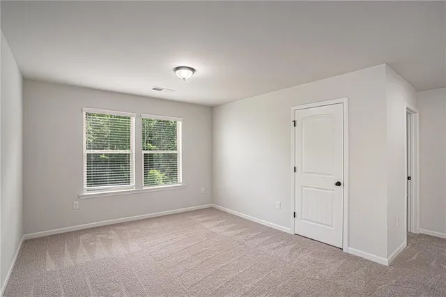 an empty room with closet and a bathroom