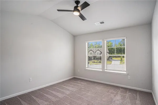 an empty room with a window and a ceiling fan