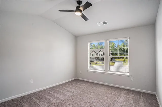 an empty room with a window and a ceiling fan