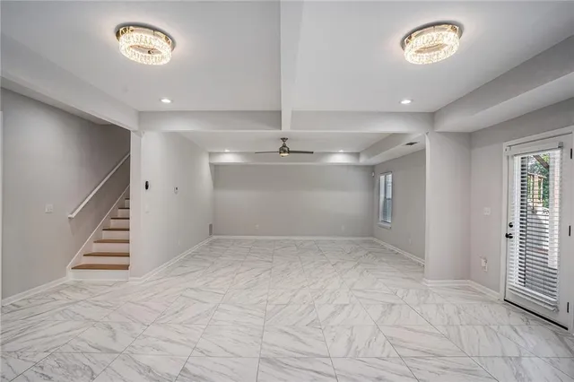 a view of a livingroom with a ceiling fan & kitchen view