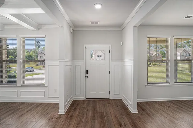 an empty room with wooden floor and windows