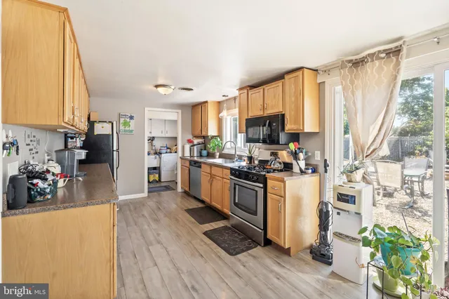 a kitchen with stainless steel appliances a stove top oven a sink and a refrigerator