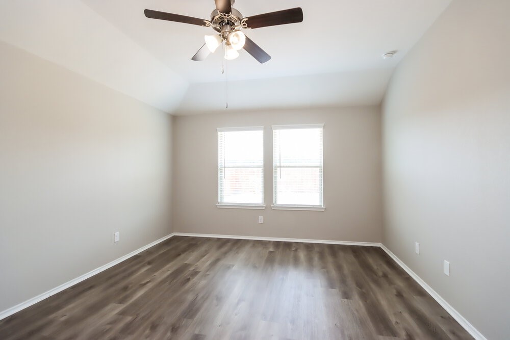 18378 Timbermill Lane New Caney, TX 77357 - Photo 14 of 16 an empty room with wooden floor fan and windows