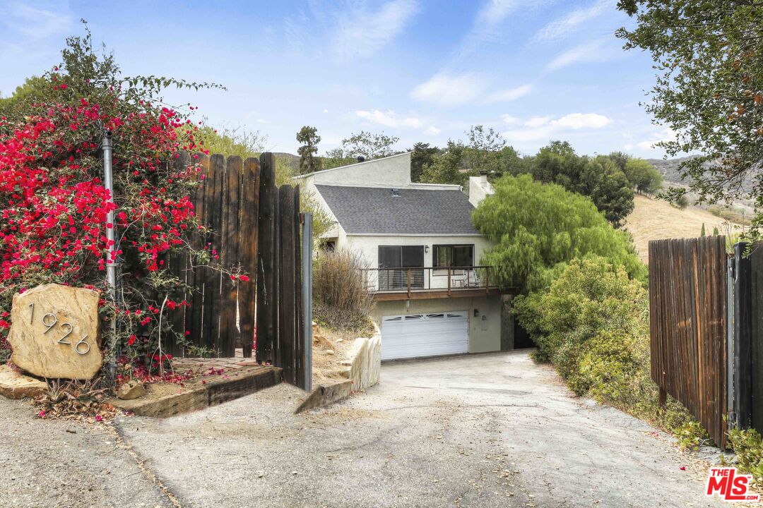 1926 Corral Canyon Road Malibu, CA 90265 - Photo 2 of 29 a front view of a house with a yard and tree s