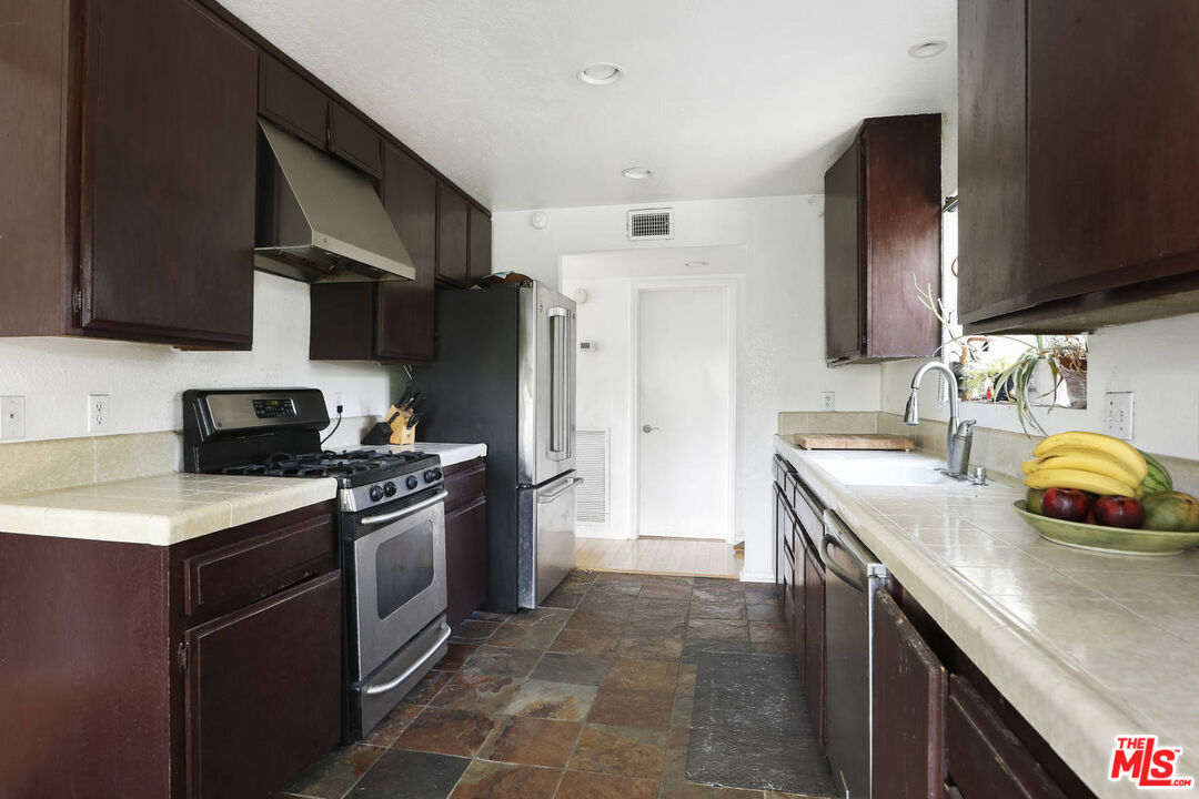 1926 Corral Canyon Road Malibu, CA 90265 - Photo 13 of 29 a kitchen with stainless steel appliances granite countertop a sink stove and refrigerator