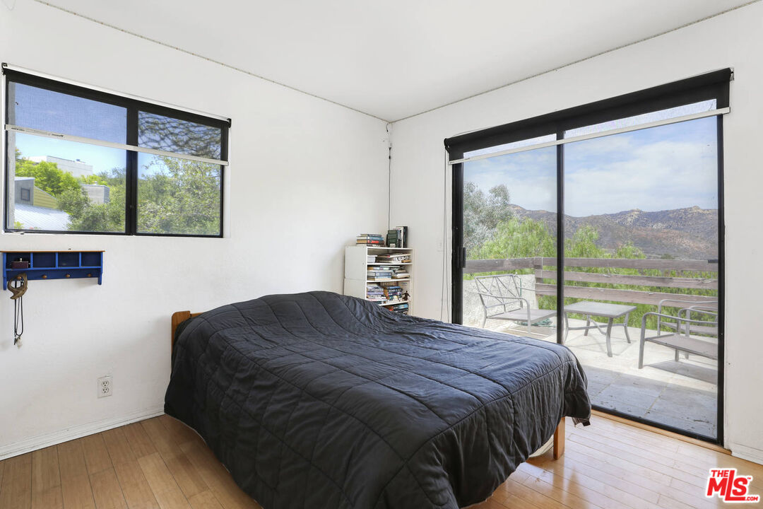 1926 Corral Canyon Road Malibu, CA 90265 - Photo 23 of 29 a bedroom with a bed and a large window