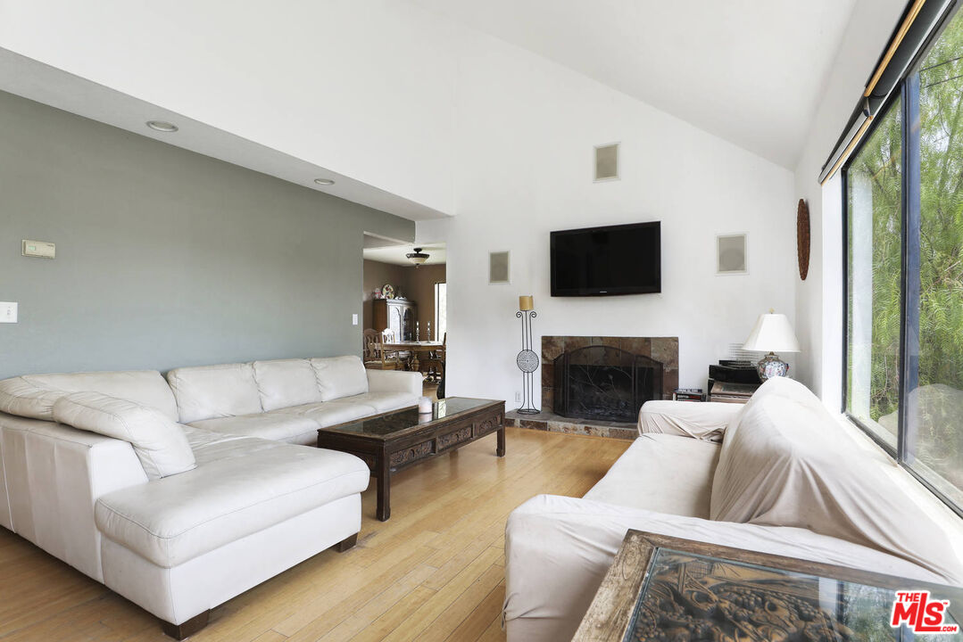 1926 Corral Canyon Road Malibu, CA 90265 - Photo 4 of 29 a living room with furniture a fireplace and a flat screen tv