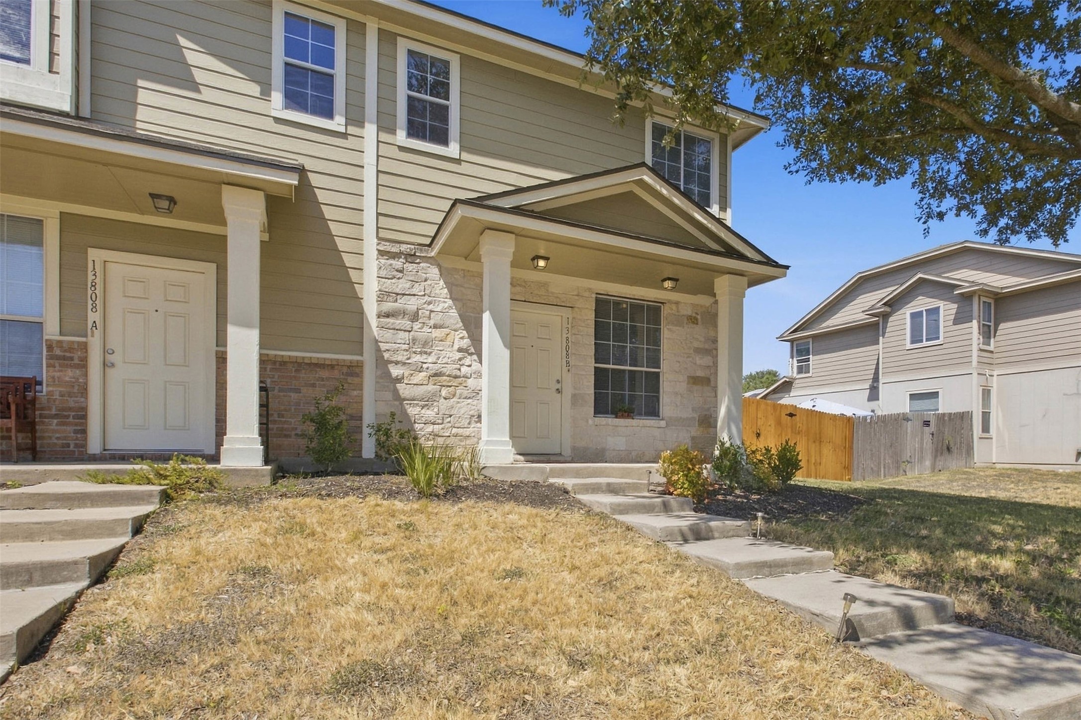 13808 Harris Ridge Boulevard, Unit B Pflugerville, TX 78660 - Photo 4 of 33 Concrete steps lead to a covered entryway flanked by classic stone and siding accents.