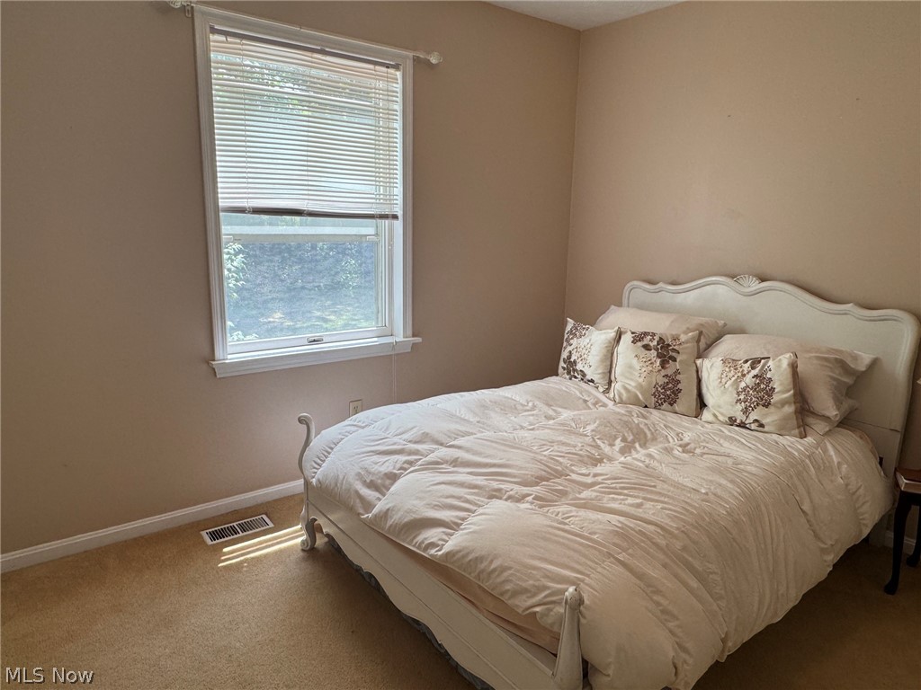 8201 Orchard Road Painesville, OH 44077 - Photo 31 of 45 Carpeted room featuring a single window with blinds, beige wall paint, white trim, and a floor vent