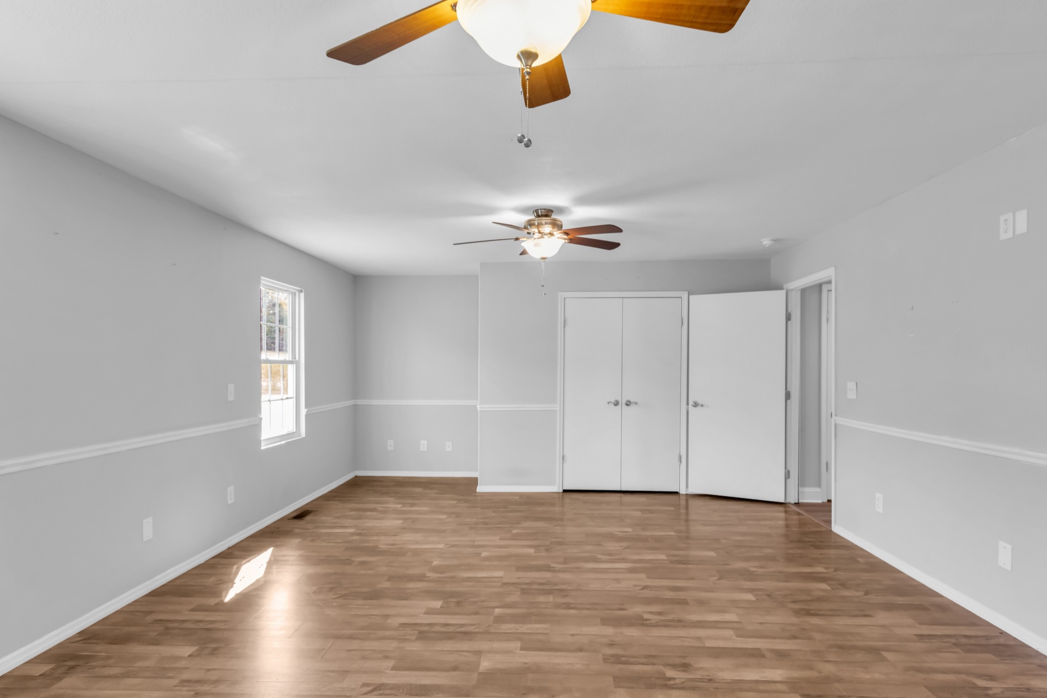 2190 Unionville Deason Road Bell Buckle, TN 37020 - Photo 16 of 34 an empty room with wooden floor chandelier fan and windows