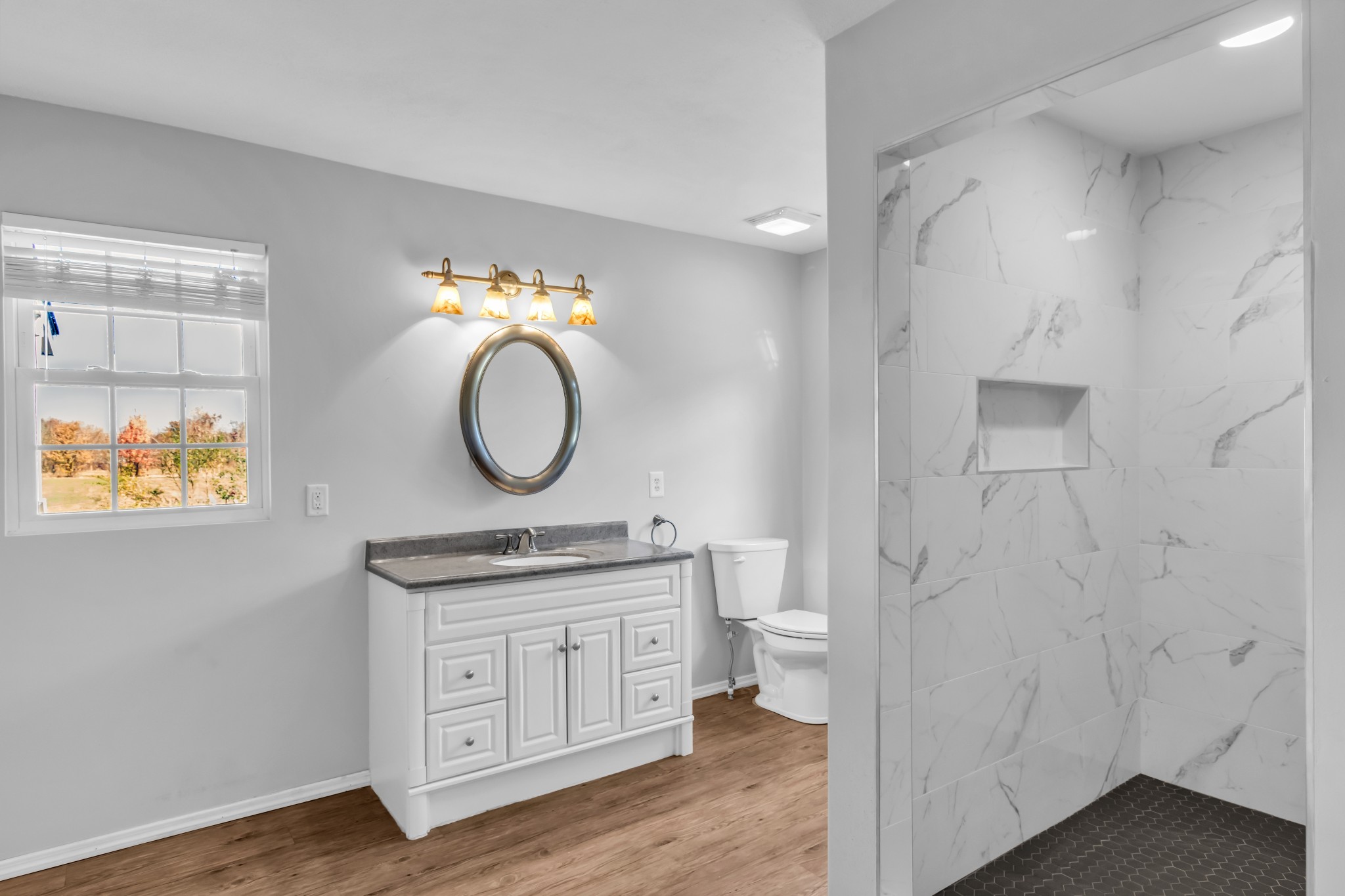 2190 Unionville Deason Road Bell Buckle, TN 37020 - Photo 17 of 34 a bathroom with a granite countertop toilet a sink and a mirror