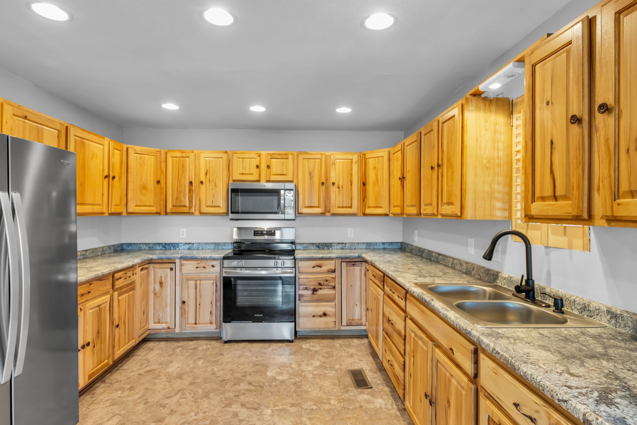 2190 Unionville Deason Road Bell Buckle, TN 37020 - Photo 9 of 34 a kitchen with stainless steel appliances granite countertop a sink a stove top oven a refrigerator with grey cabinets