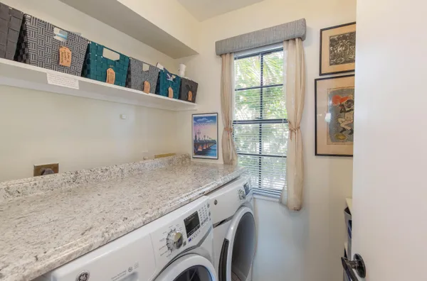 a bathroom with a granite countertop sink and a window
