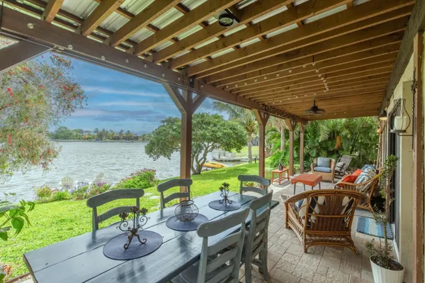 a view of a patio with couches chairs potted plants and wooden floor