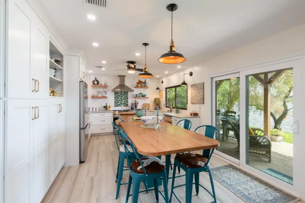 a view of a dining room and livingroom with furniture wooden floor a chandelier
