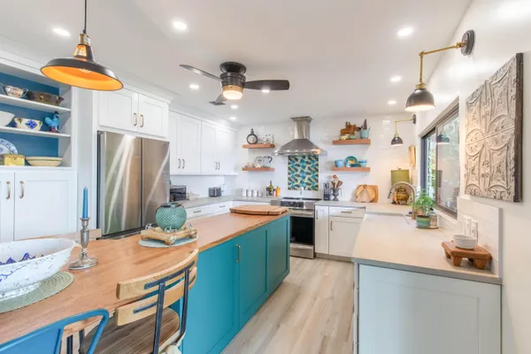 a kitchen with stainless steel appliances granite countertop a sink a stove a refrigerator and island