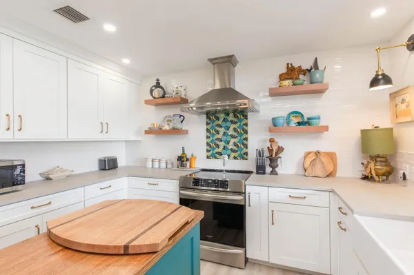 a kitchen with stainless steel appliances granite countertop a sink stove and cabinets