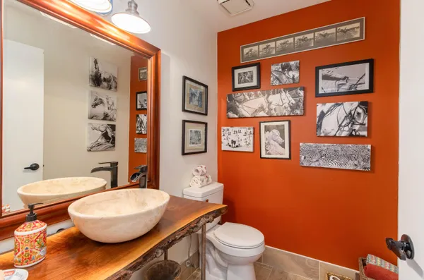 a bathroom with a granite countertop toilet and a mirror