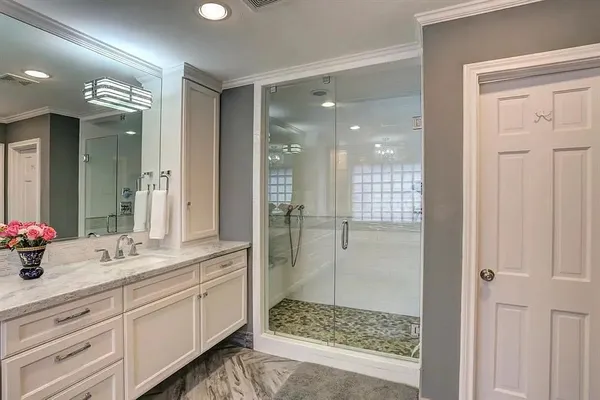 a bathroom with a double vanity sink mirror and shower