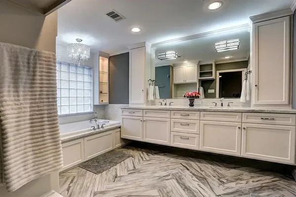 a bathroom with a double vanity sink a mirror and a bathtub
