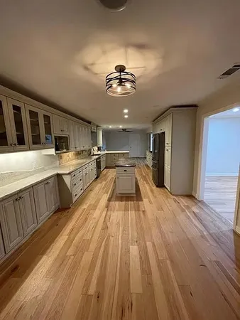 a view of a kitchen with a sink wooden floor and chandelier
