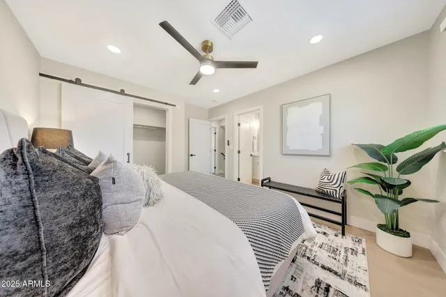 a bedroom with a bed potted plant with the wooden floor