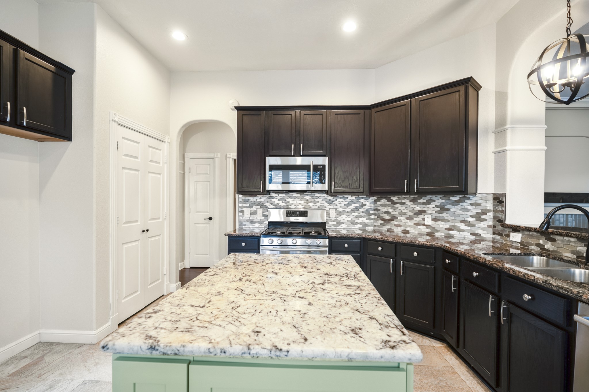 5802 Sawyer Bend Lane Spring, TX 77379 - Photo 11 of 50 a large kitchen with kitchen island granite countertop wooden cabinets and a sink