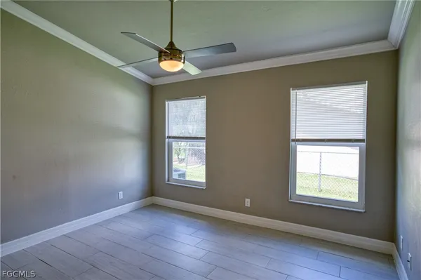 a view of an empty room with a window and wooden floor