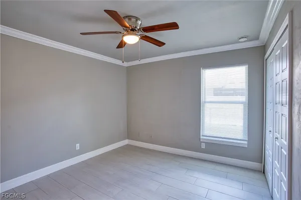 an empty room with a window and a fan
