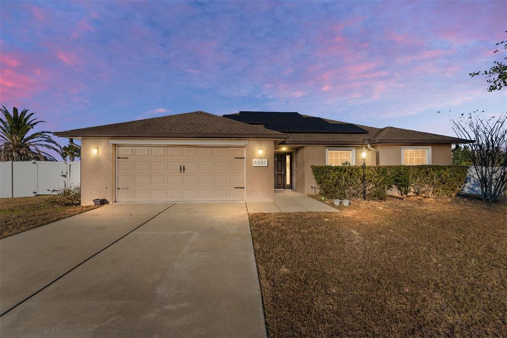 9961 Southwest 55th Ave Road Ocala, FL 34476 - Photo 1 of 89 a front view of a house with a yard and garage