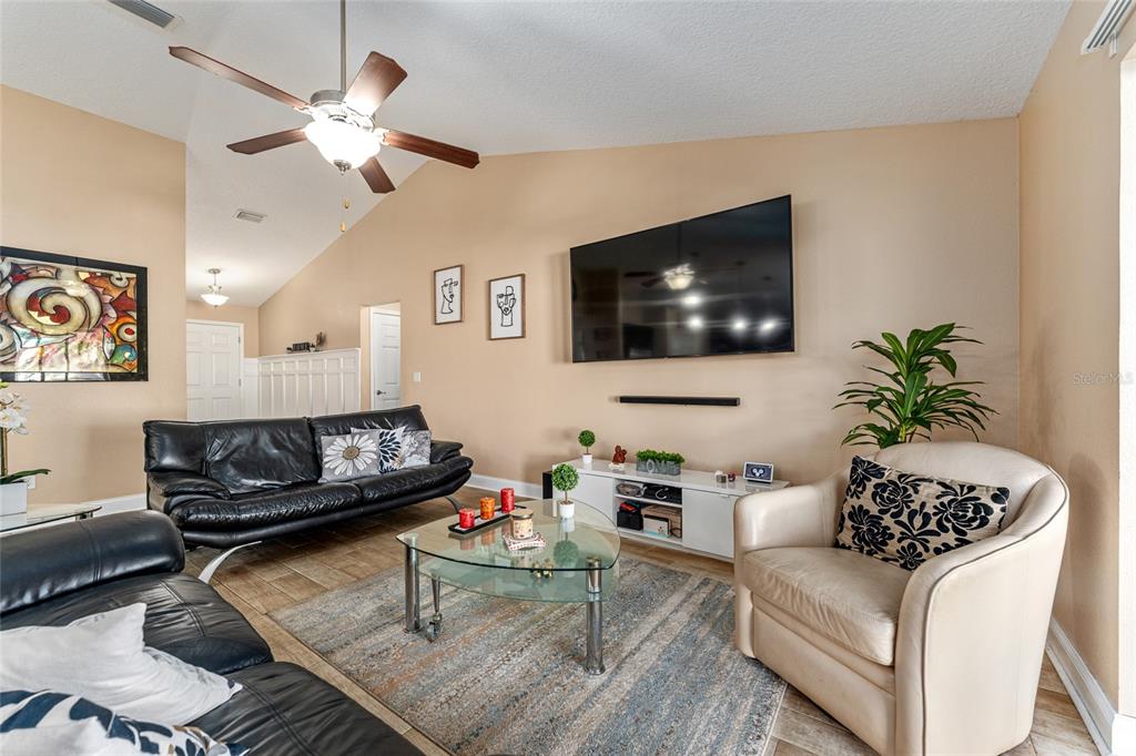 9961 Southwest 55th Ave Road Ocala, FL 34476 - Photo 18 of 89 a living room with furniture and a flat screen tv