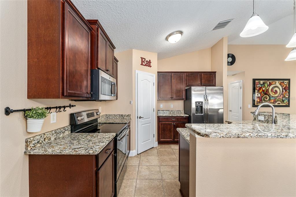 9961 Southwest 55th Ave Road Ocala, FL 34476 - Photo 26 of 89 a kitchen with stainless steel appliances granite countertop a sink stove and refrigerator