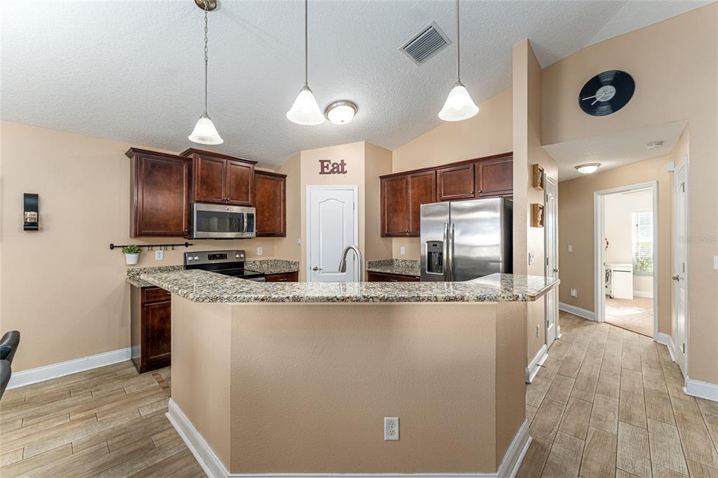 9961 Southwest 55th Ave Road Ocala, FL 34476 - Photo 27 of 89 a kitchen with stainless steel appliances granite countertop a sink refrigerator and microwave