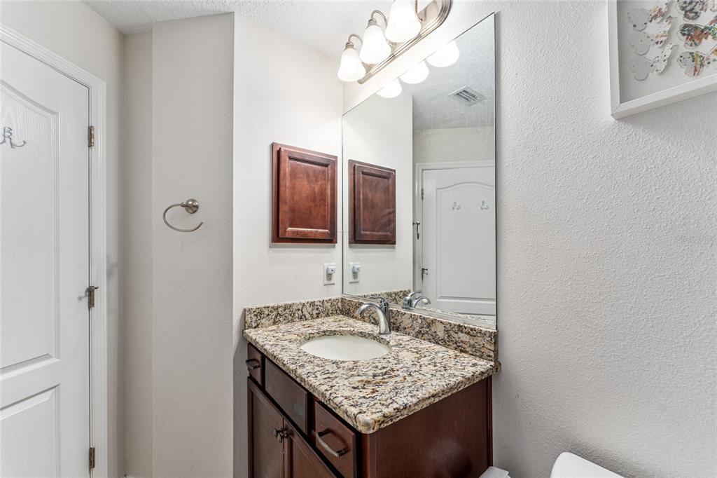 9961 Southwest 55th Ave Road Ocala, FL 34476 - Photo 39 of 89 a bathroom with a granite countertop sink and a mirror