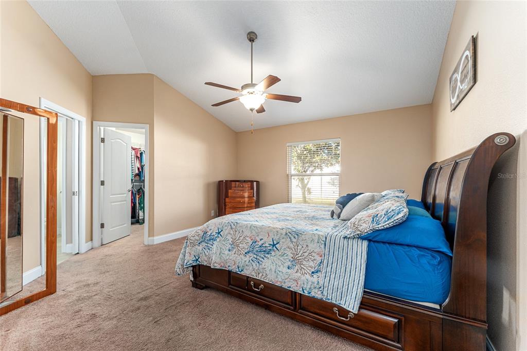 9961 Southwest 55th Ave Road Ocala, FL 34476 - Photo 40 of 89 a bedroom with a bed and a chandelier