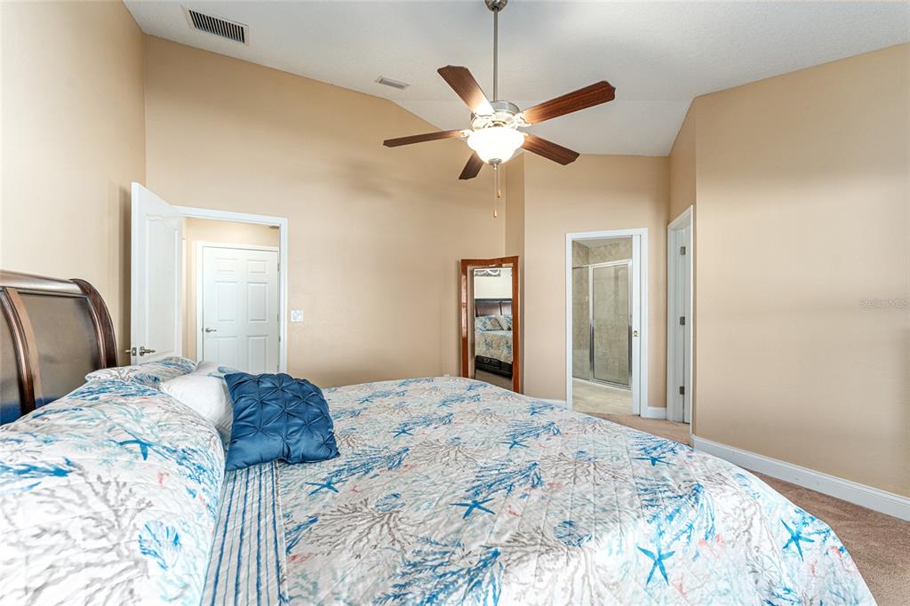 9961 Southwest 55th Ave Road Ocala, FL 34476 - Photo 41 of 89 a bedroom with a large bed and a chandelier