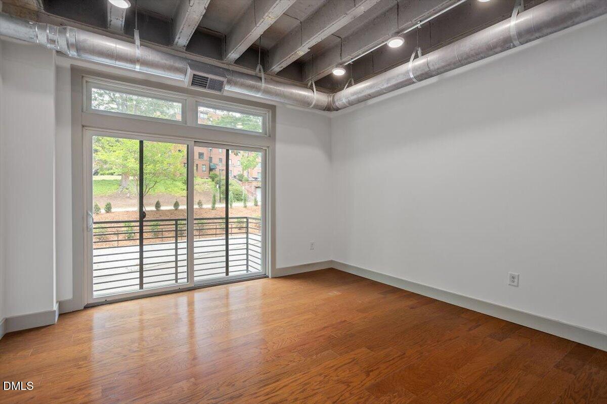 1300 St Marys Street, Unit 207 Raleigh, NC 27605 - Photo 5 of 31 an empty room with wooden floor and windows