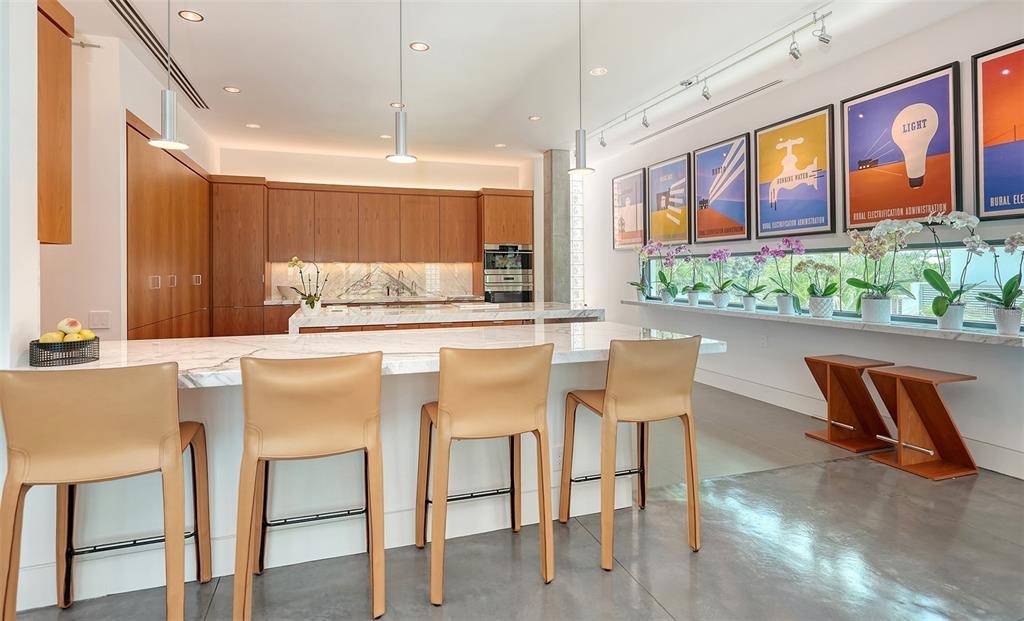 8250 Sanderling Road Sarasota, FL 34242 - Photo 23 of 61 a kitchen with a table chairs refrigerator and microwave