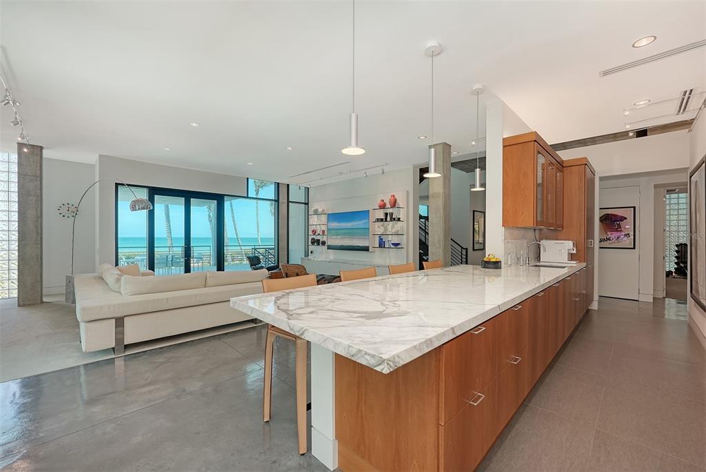 8250 Sanderling Road Sarasota, FL 34242 - Photo 26 of 61 a large kitchen with kitchen island a large counter top space a sink stainless steel appliances and cabinets