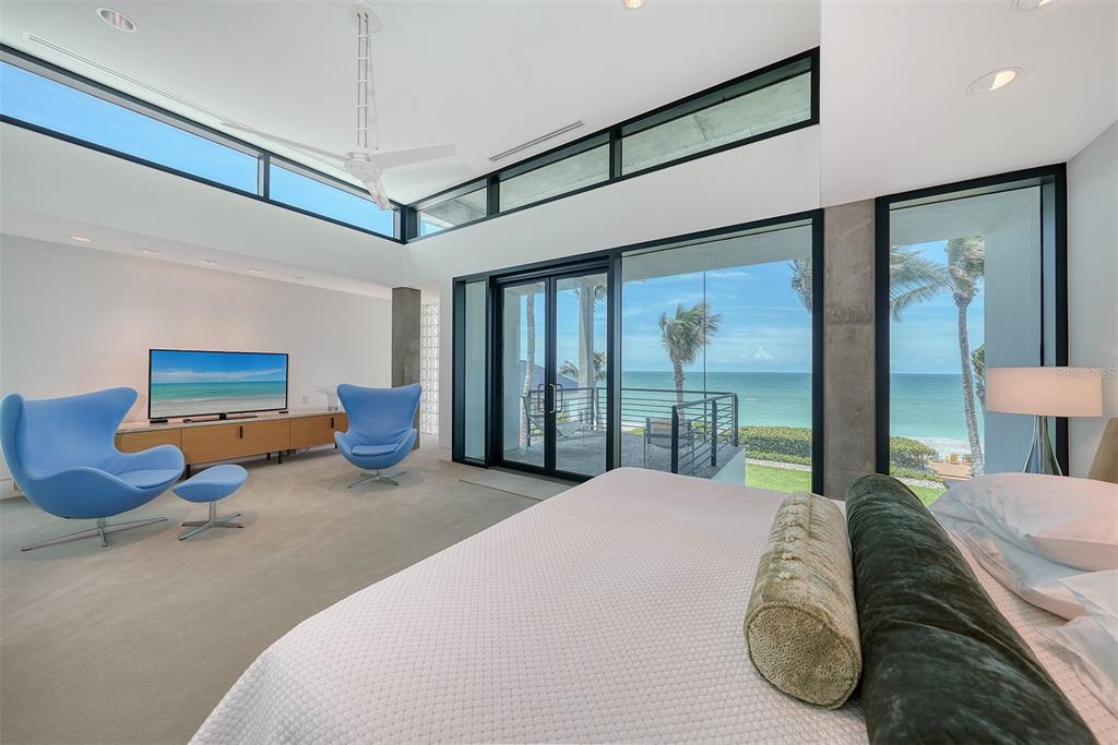 8250 Sanderling Road Sarasota, FL 34242 - Photo 29 of 61 a bedroom with furniture and large windows