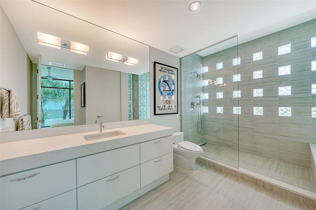 8250 Sanderling Road Sarasota, FL 34242 - Photo 36 of 61 a spacious bathroom with a shower sink and mirror