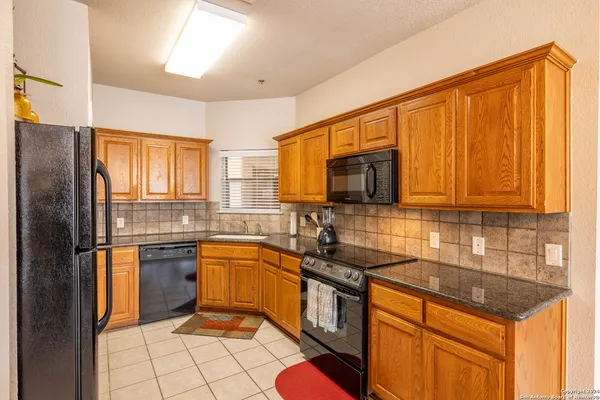 a kitchen with stainless steel appliances granite countertop a stove a sink dishwasher and a refrigerator
