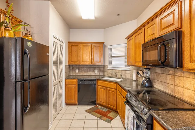 a kitchen with stainless steel appliances granite countertop a refrigerator stove and sink