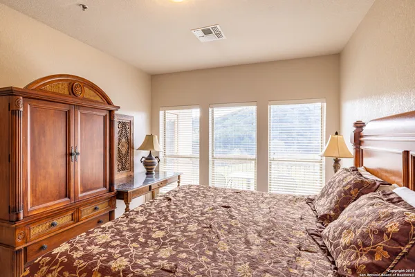 a bedroom with a bed and a large window with outer view